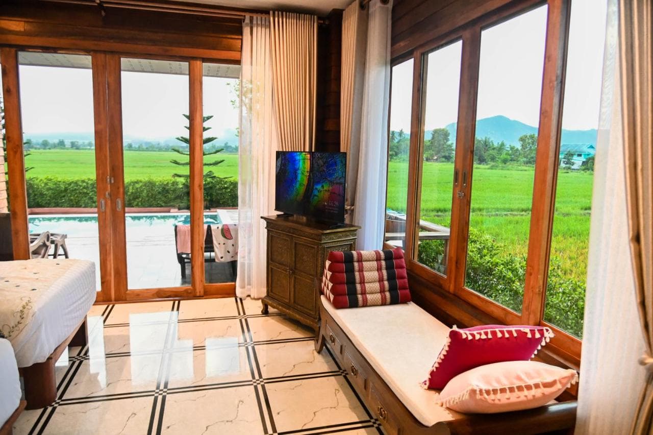 Guest room at Doona Resort with wide windows overlooking rice fields