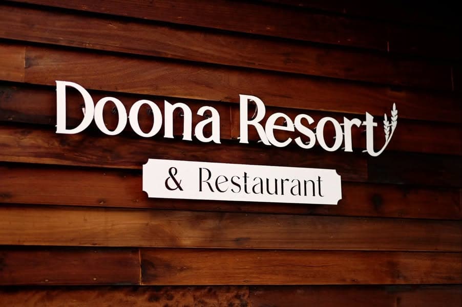 ป้ายชื่อ Doona Resort and Restaurant บนไม้สักท้องถิ่น